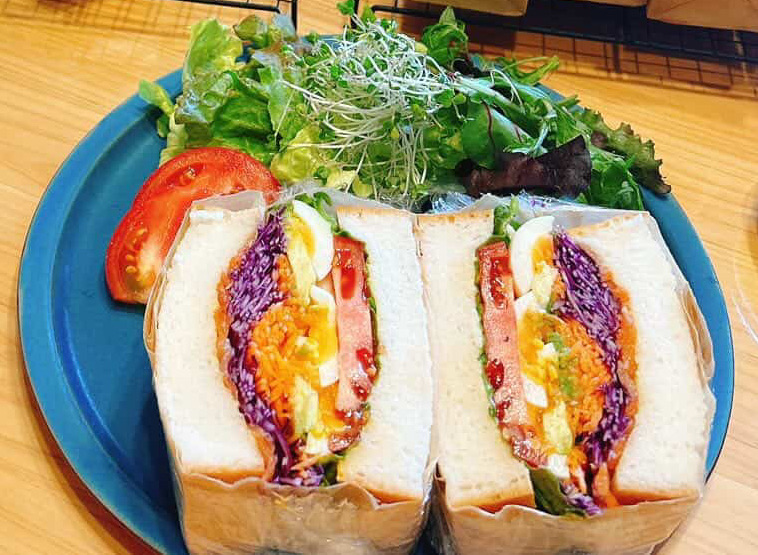 生米アボカドサーモンサンド。彩り野菜とサーモン、アボカドを生米パンではさんだサンド